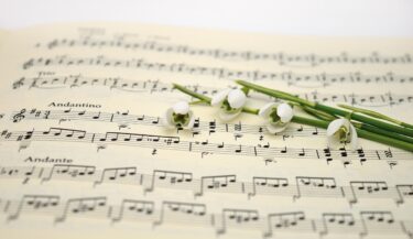Du muguet posé sur une partition de musique.