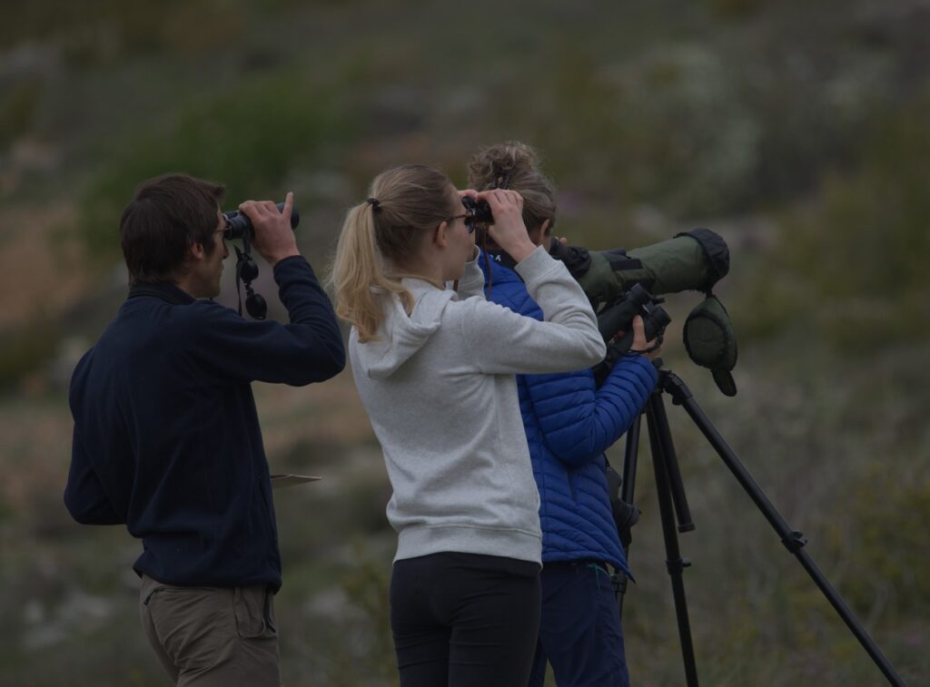 3 personnes regardant dans des jumelles