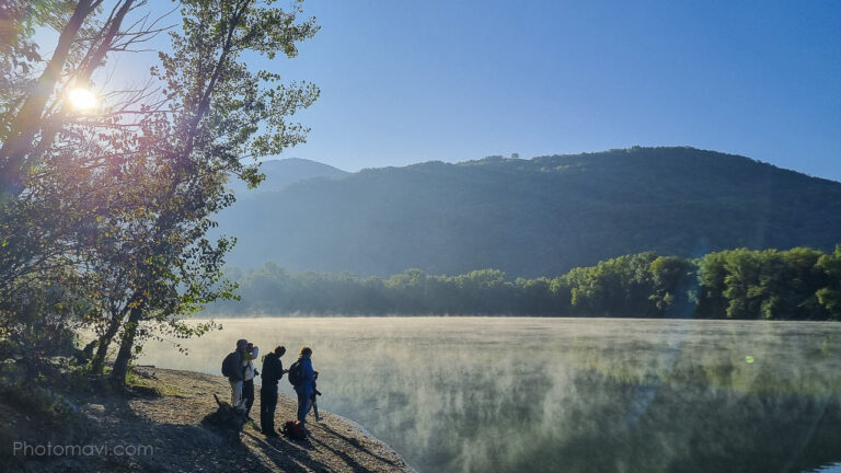 Groupe de personnes au bord d'un lac regardant dans les jumelles