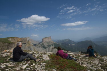 Trois personnes assises regardant les montagnes